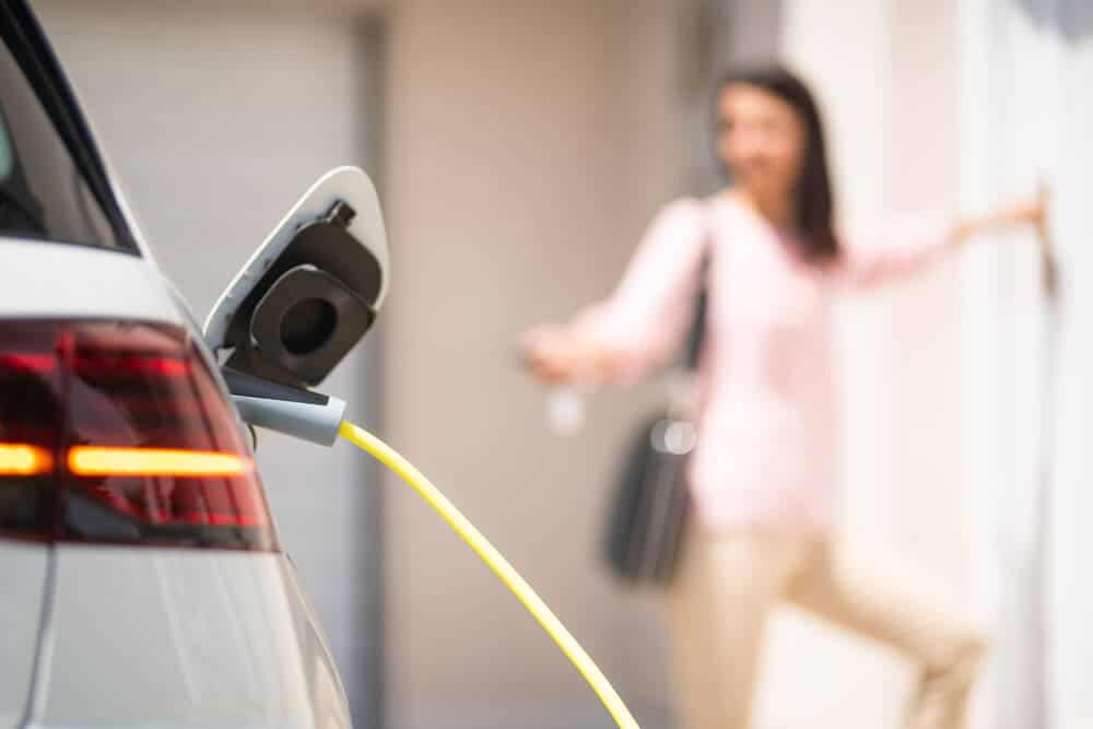Une femme qui recharge sa voiture électrique